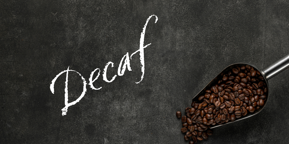Chalkboard with "Decaf" written on it and a scoop of coffee beans